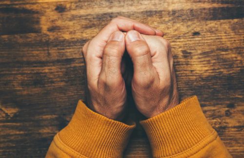 top-view-of-religious-male-crossed-hands-in-prayer-2023-11-27-05-12-51-utc